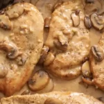 Creamy Chicken Marsala with golden brown chicken cutlets smothered in rich mushroom wine sauce, served over pasta